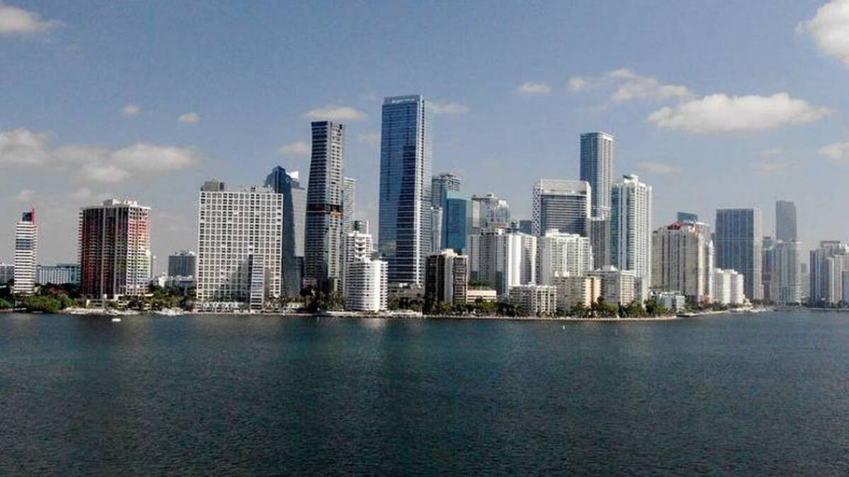 Miami real estate market warning sign with concerned investors in background.