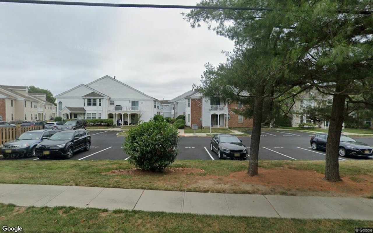 Real estate agents gather around luxury property listings in downtown Freehold, New Jersey.