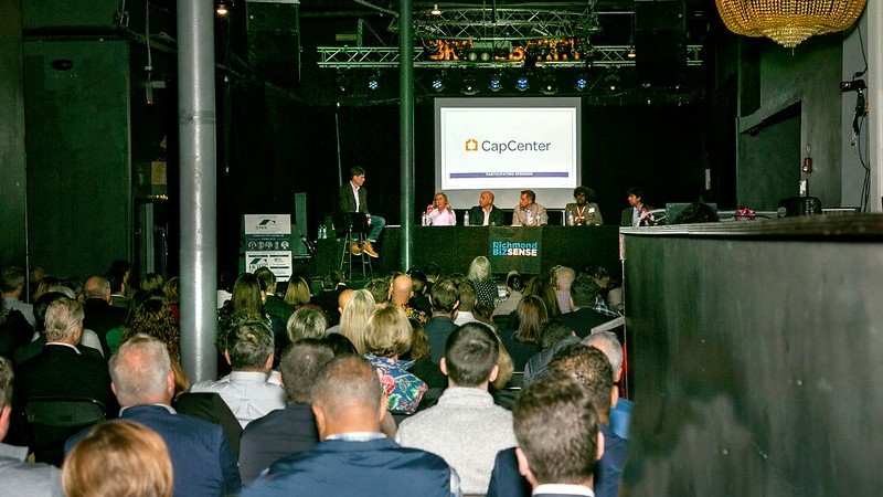 Real estate professionals discuss residential market trends at open house event.