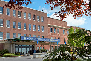 Brockton hospital construction site with cranes and workers in Massachusetts.