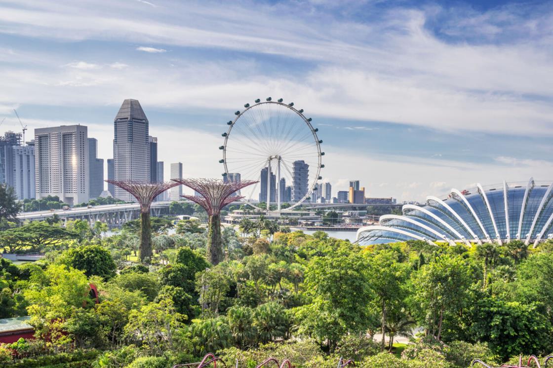 Hines executive stands in front of Asian cityscape with business partners.