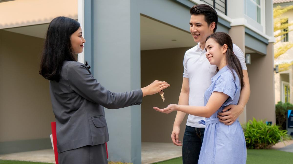 Gen Z investors gather around real estate investment charts in a conference room.