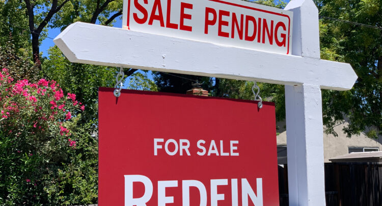 Redfin executive in conference room with US housing market recovery charts behind.