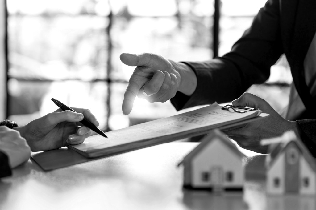 Businessman standing in front of office building with lawyer discussing property rights.