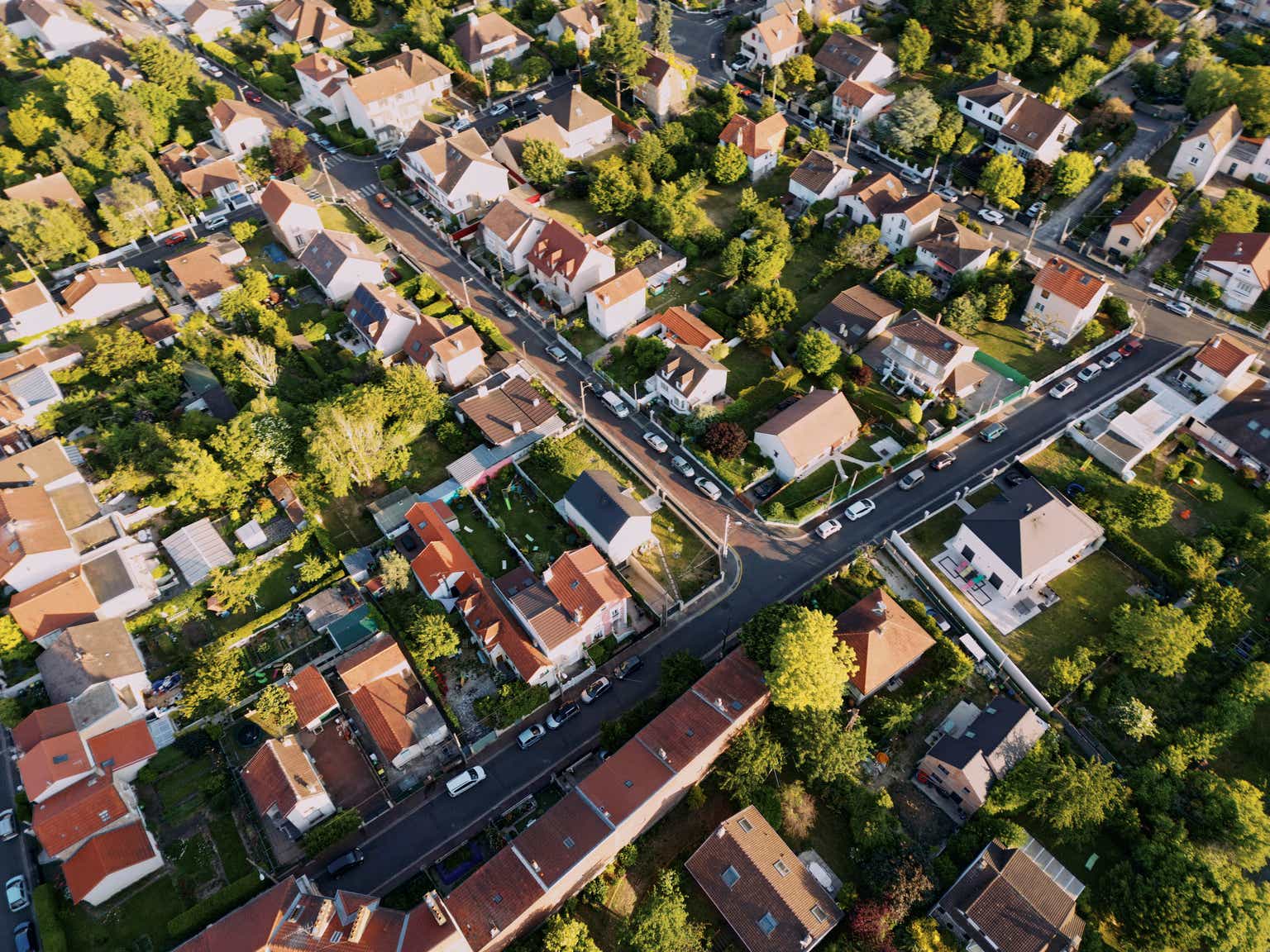 Homes in urban areas with construction equipment and rising market indicators.