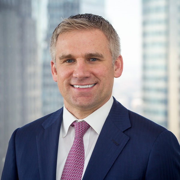 JP Morgan Chase executive Burke Davis in office setting with cityscape background.