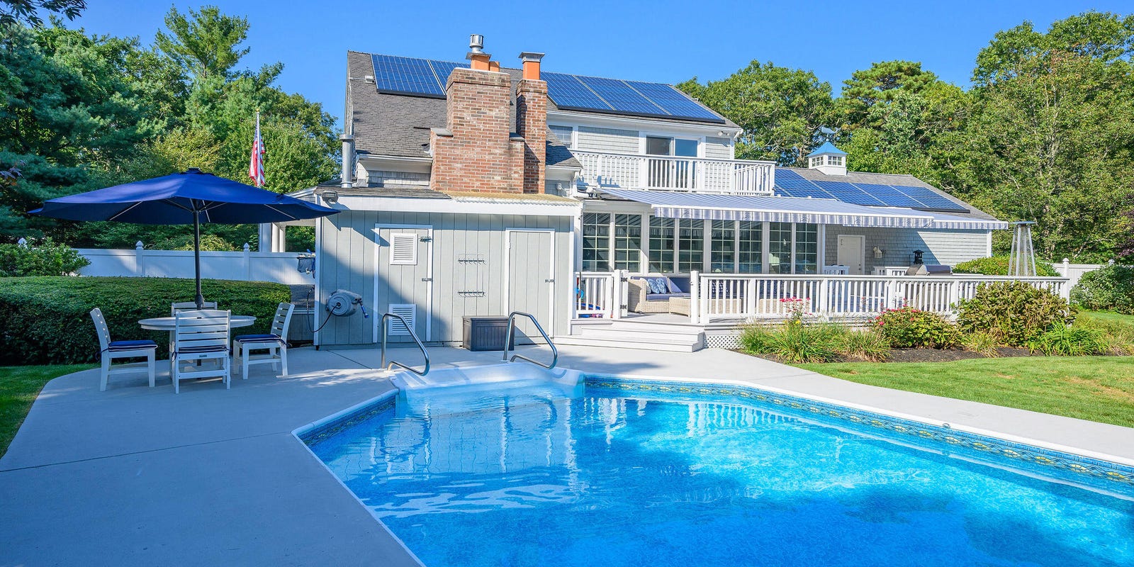 Coastal dream home with saltwater pool, porch, and yard in beachside location.