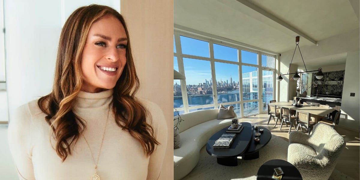 Single woman stands in front of her newly purchased home, smiling.