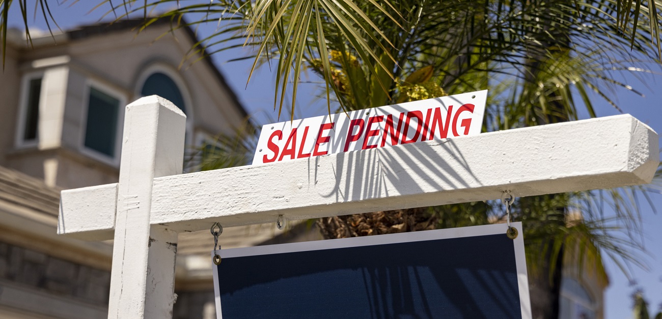 Image: Real estate agent showing house keys to excited buyers.