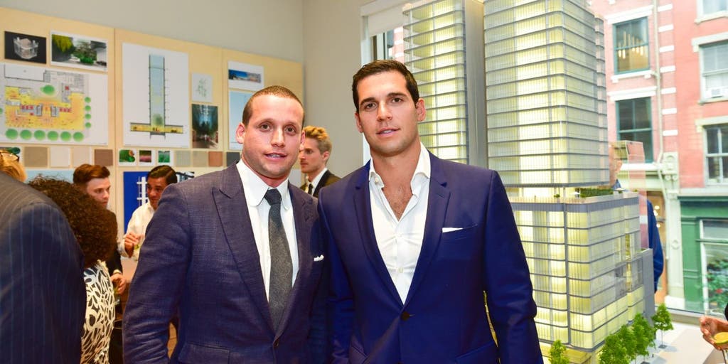 Tal and Oren Alexander, high-end real estate powerbrokers, standing in front of buildings.