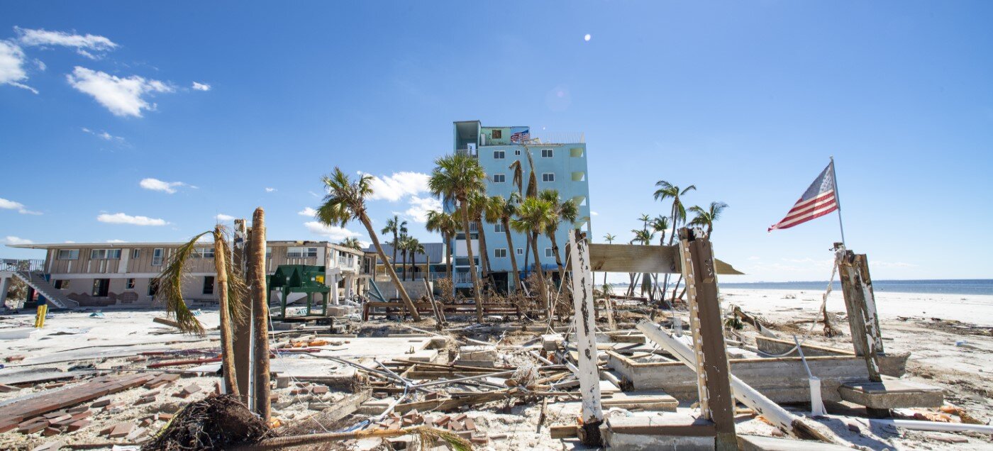 Senior couple inspecting coastal property despite high disaster risk.