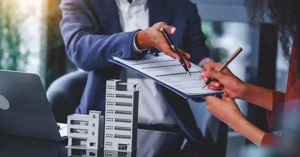 Businesswoman reviewing documents in office, delegating property management tasks.