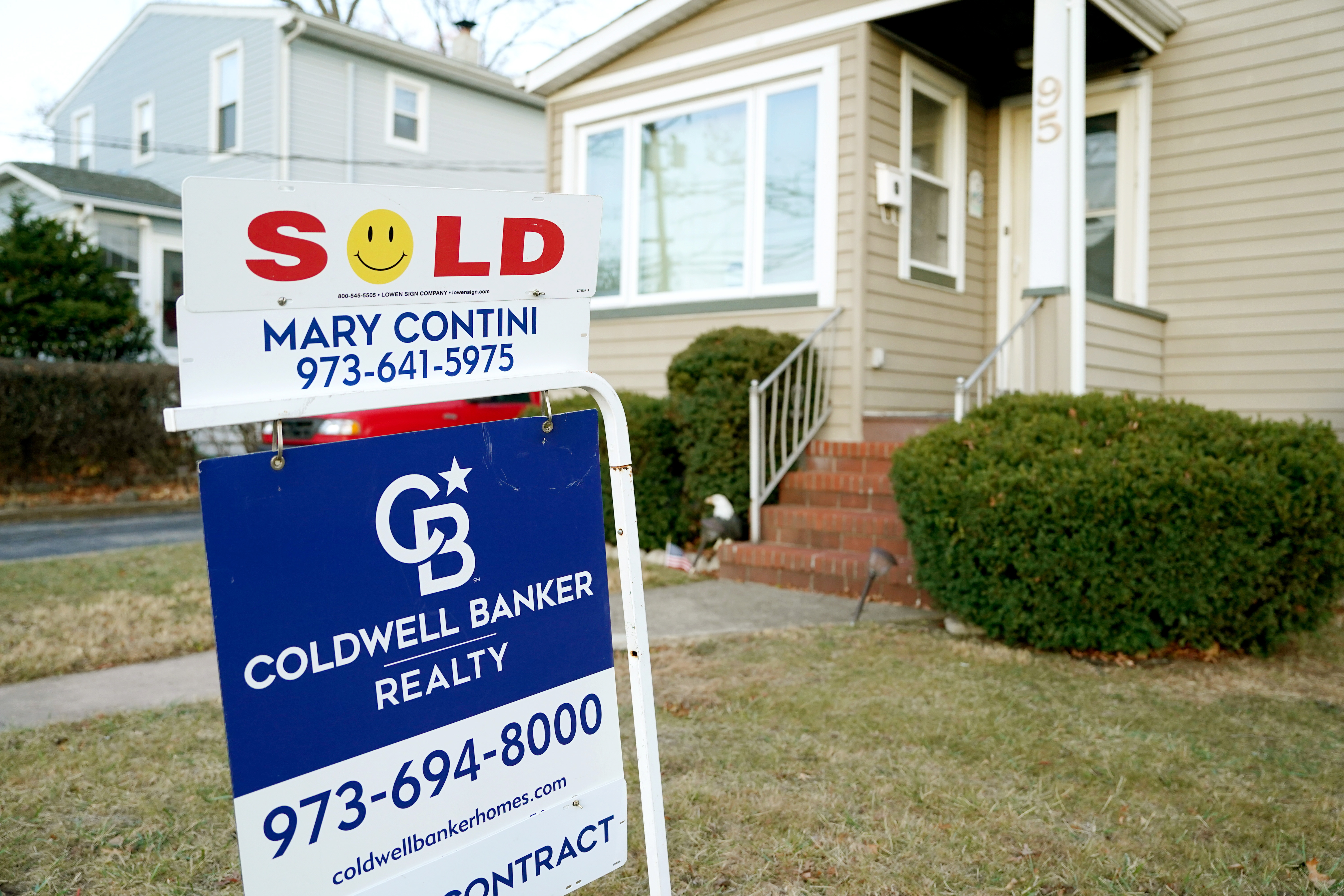 Image: Busy real estate office with agents and clients celebrating successful home sales.