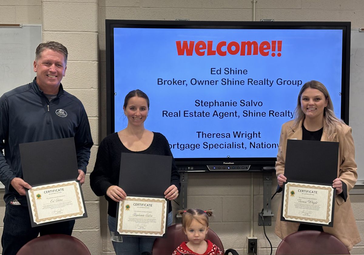 Realtors teach high school students about real estate in a classroom setting.