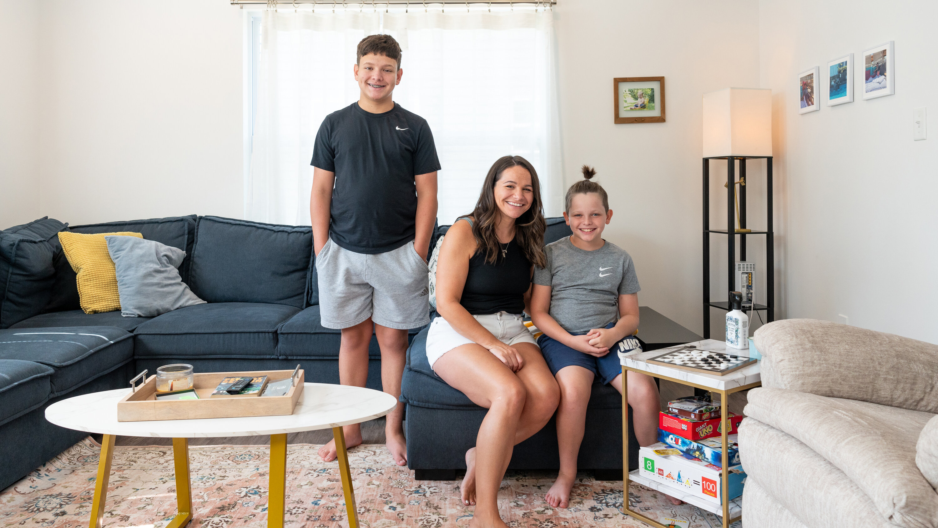 Family standing in front of a house, weighing homeownership versus renting options.