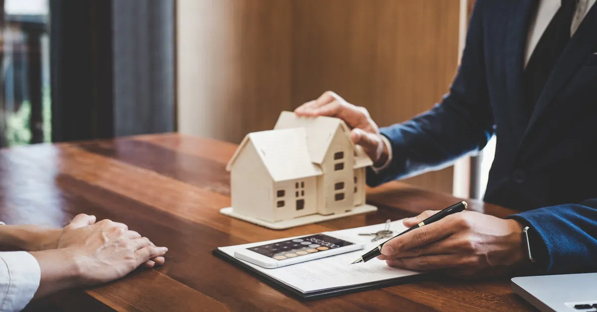 Real estate agents discuss interest rate reduction effects in a conference setting.