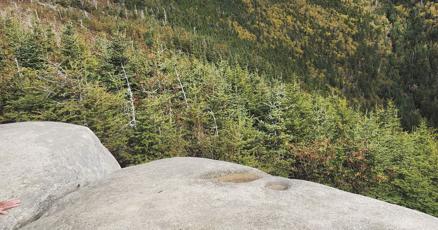 Hikers trek through vibrant fall foliage in New Hampshire's scenic mountains.