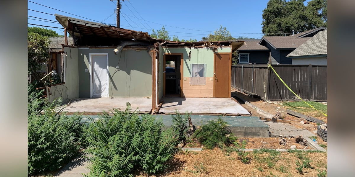 Half-crushed house for sale in a suburban neighborhood with a 'For Sale' sign.