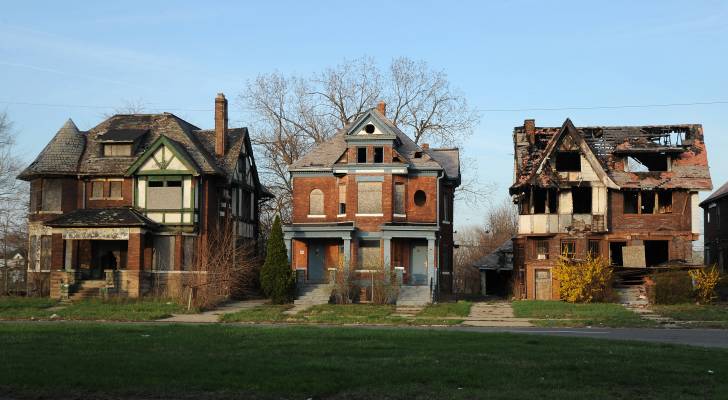 Real estate investor woman standing in front of multiple properties, smiling.