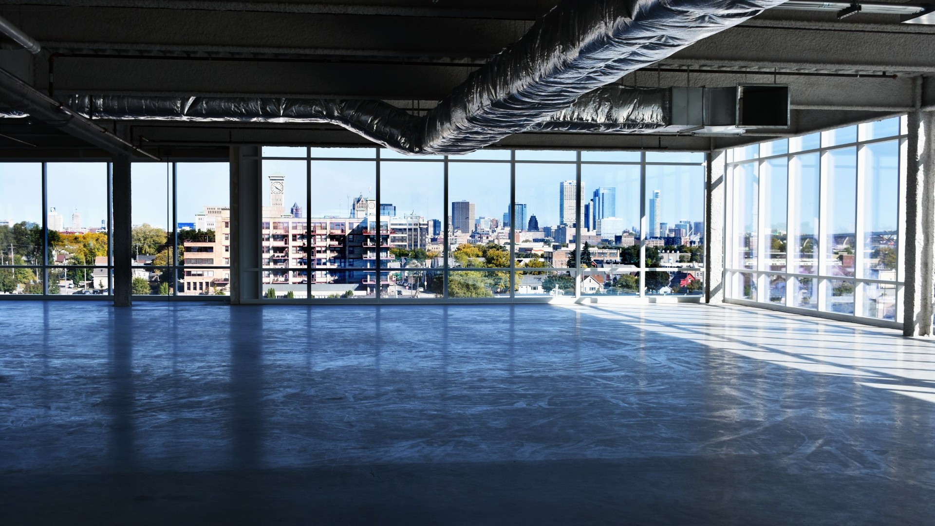 Empty office building in downtown Milwaukee with 'For Rent' signs displayed.