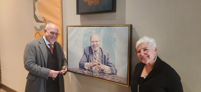 Portrait of Stan Zukin, real estate expert, with city skyline background.