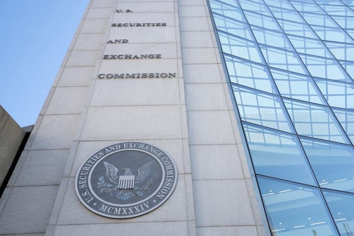 SEC official reviewing real estate investment documents in a conference room.