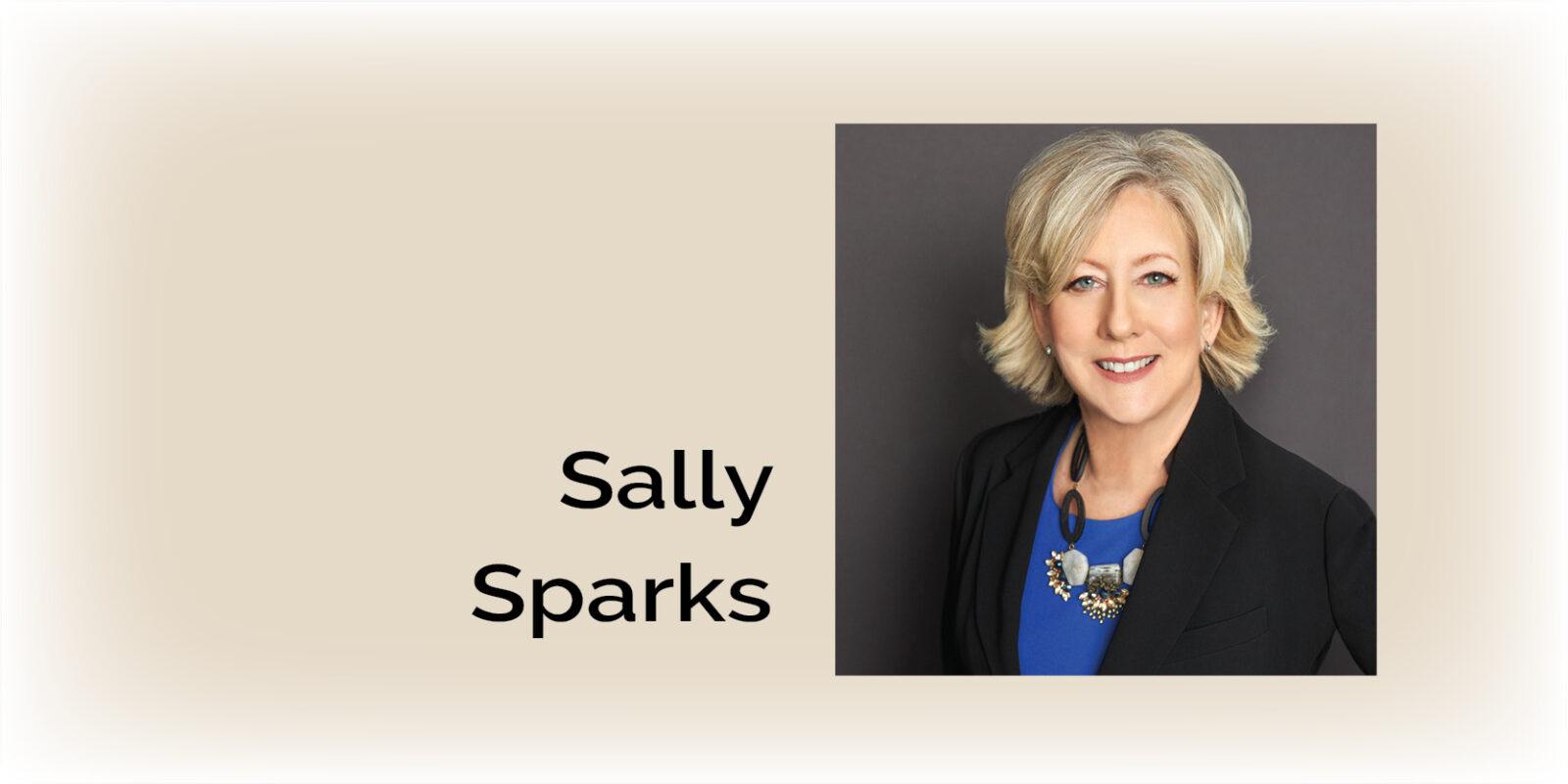 Sally Sparks returns to Wallace Real Estate, smiling with colleagues in office.