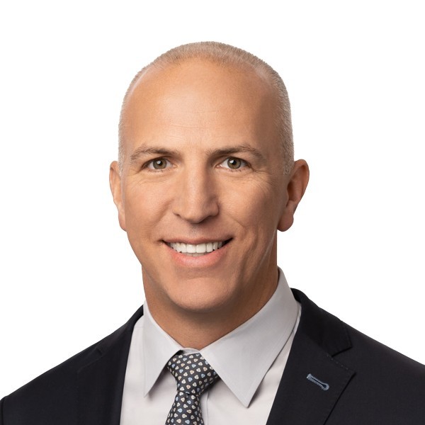 Bain Capital executive Keith Largay in office, with Boston cityscape background.