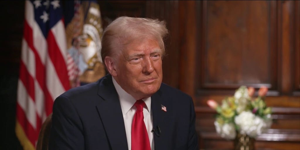 Donald Trump standing in front of a Gaza Strip map, smiling.