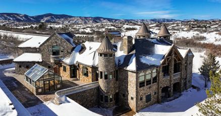 Colorado castle with three turrets for sale, historic landmark in mountainous region.