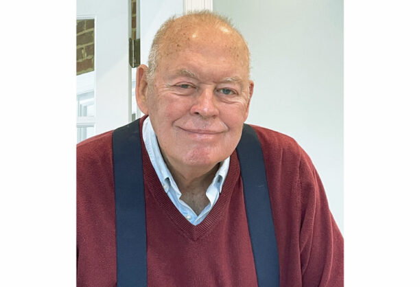 Portrait of Dick Edwards, West Plains real estate trailblazer, standing in front of a house.